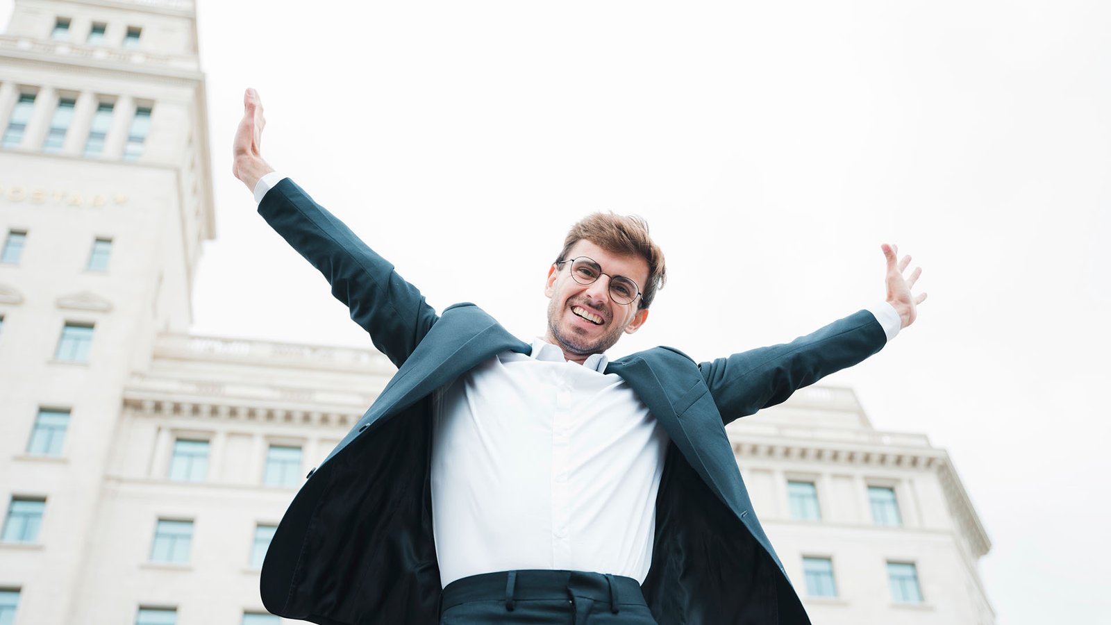 Hombre sonriente celebrando su éxito financiero al aire libre